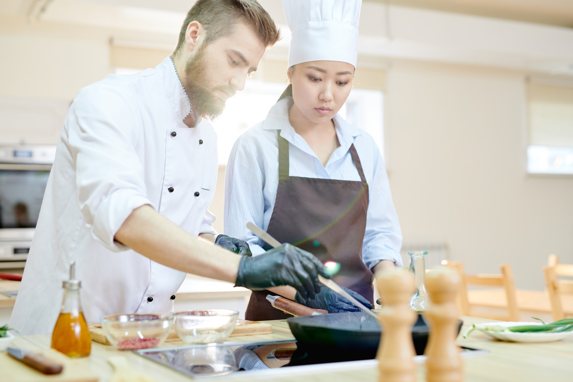 Chef guiding a participant in a modern kitchen